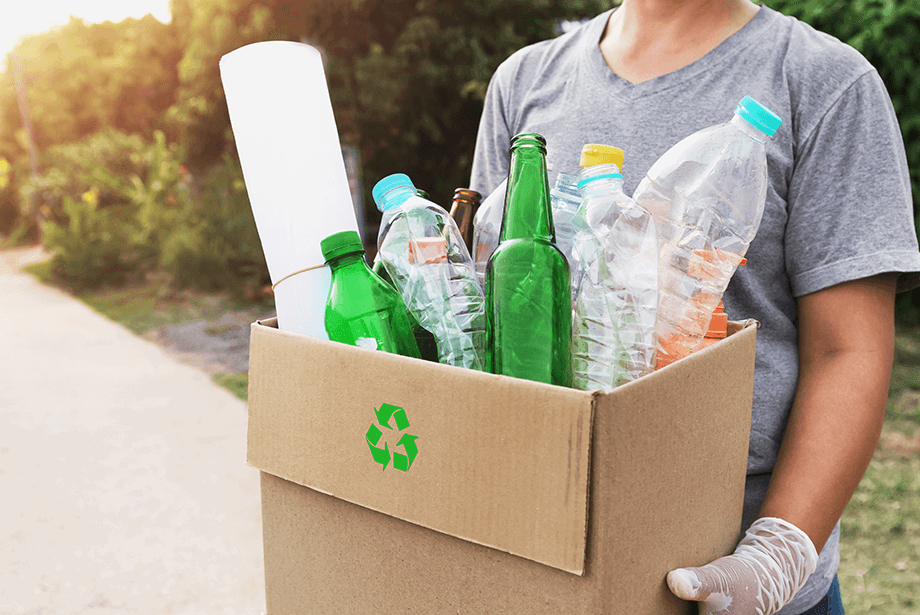 Box filled with recycling including plastic and glass bottles 