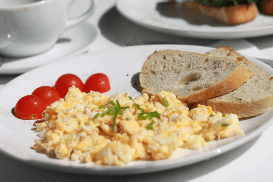 Soft and fluffy scrambled egg sprinkled with chives with lightly toasted bread
