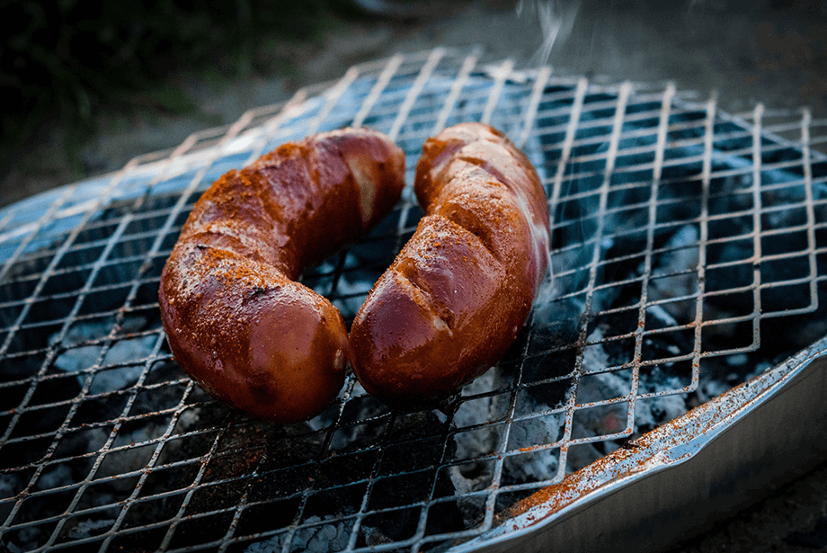 Two sausages on charcoal barbeque