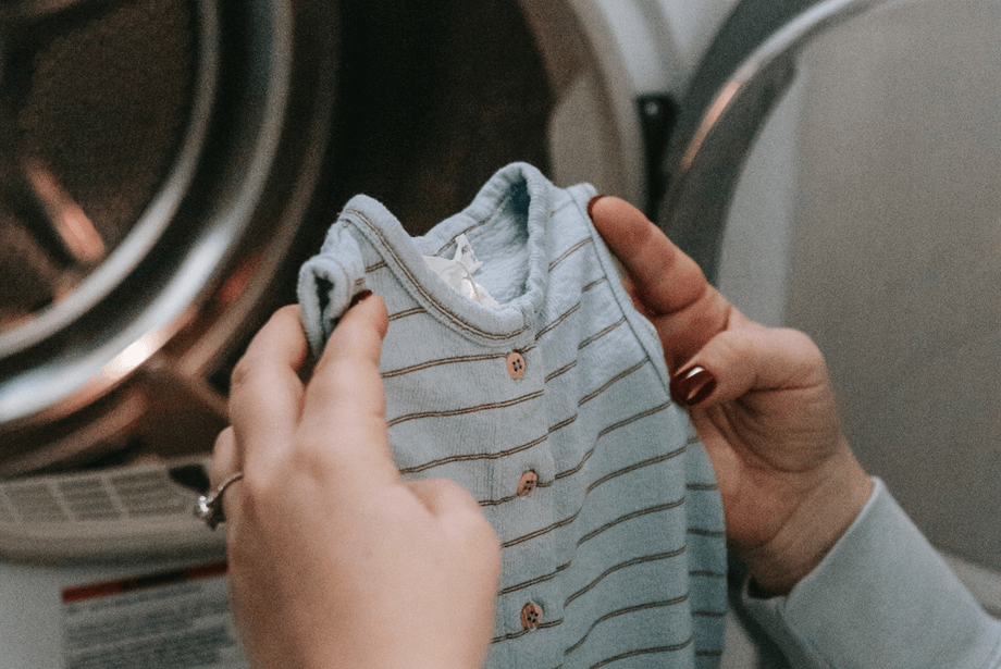 Baby grow about to be put into washing machine. Photo by Sarah Chai - Pexels