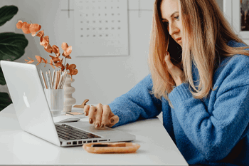 Woman working on Macbook at desk 