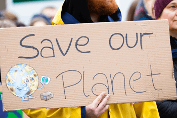 Climate protester holding 'save ourplanet' sign 