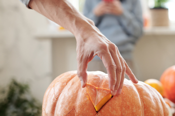 A large orange pumpkin being carved for Halloween