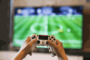 Playstation 5 (PS5) controller playing game on TV. 