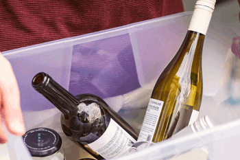 Glass bottles and jar being recycled in plastic box